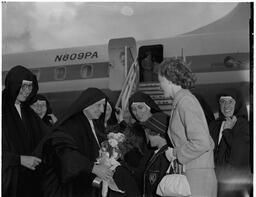 Head nun greeting Vicar General Salesians at steps of Pan American Airlines (PAA) jet