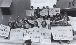 [Students holding placards on the steps of the NCPE building, protesting at conditions at the Campus Library.