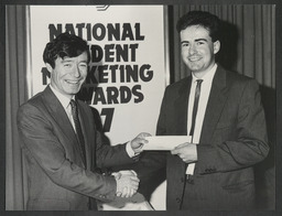 Michael Lowry presenting a national student marketing award to an unidentified recipient