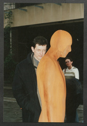 Man viewing Anthony Gormley's statue "Together and Apart" on the Plaza