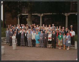 Large group standing outside Charles Harvey Tower [on the day of granting university status?]