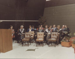 Members of staff and of Governing Body seated at graduation ceremony.