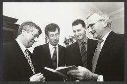 Donal Dineen, Dick Spring, Jim Deegan and Noel Whelan viewing a publication "Tourism Policy and Performance"