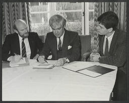 Stuart Hampshire, John McGinn and Eamonn Cregan seated at a table looking at documents