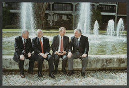 Four individuals sitting at the fountain at the back of Plassey House at the University of Limerick